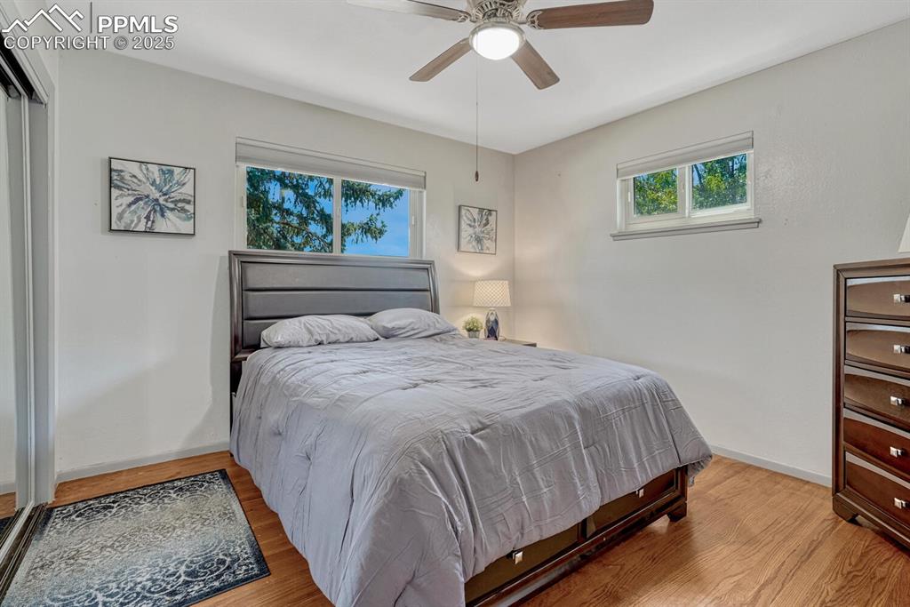 Image 13 of 38: Bedroom with wood finished floors and a ceiling fan