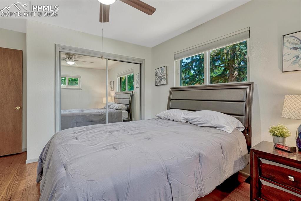 Image 14 of 38: Bedroom with wood finished floors, a ceiling fan, and a closet