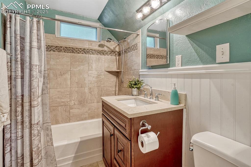 Image 19 of 38: Full bathroom featuring shower / bath combo with shower curtain, vanity, wa