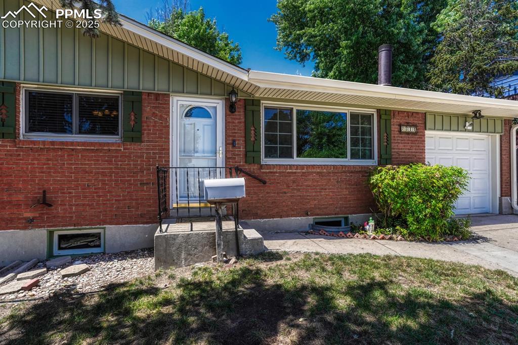 Image 2 of 38: View of front of property with an attached garage, board and batten siding,