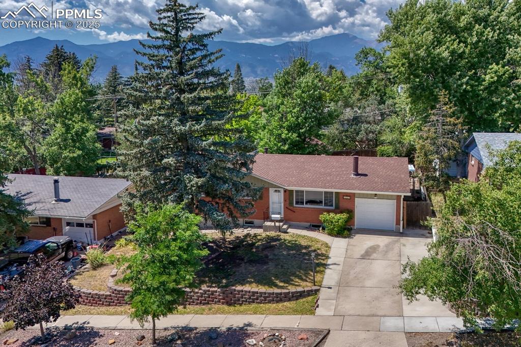 Image 33 of 38: View of front of property with a garage, concrete driveway, a mountain view