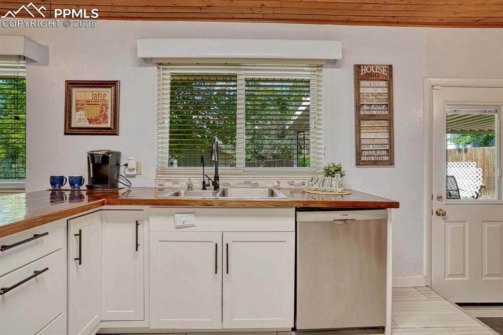 Image 9 of 38: Kitchen with dishwasher, white cabinets, and butcher block countertops