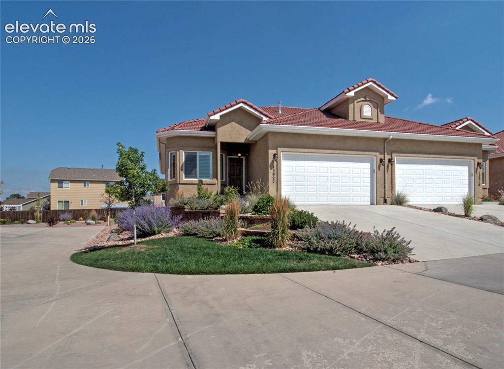 Image 1 of 33: Stucco exterior with a terra cotta tile roof, featuring a two-car garage, m