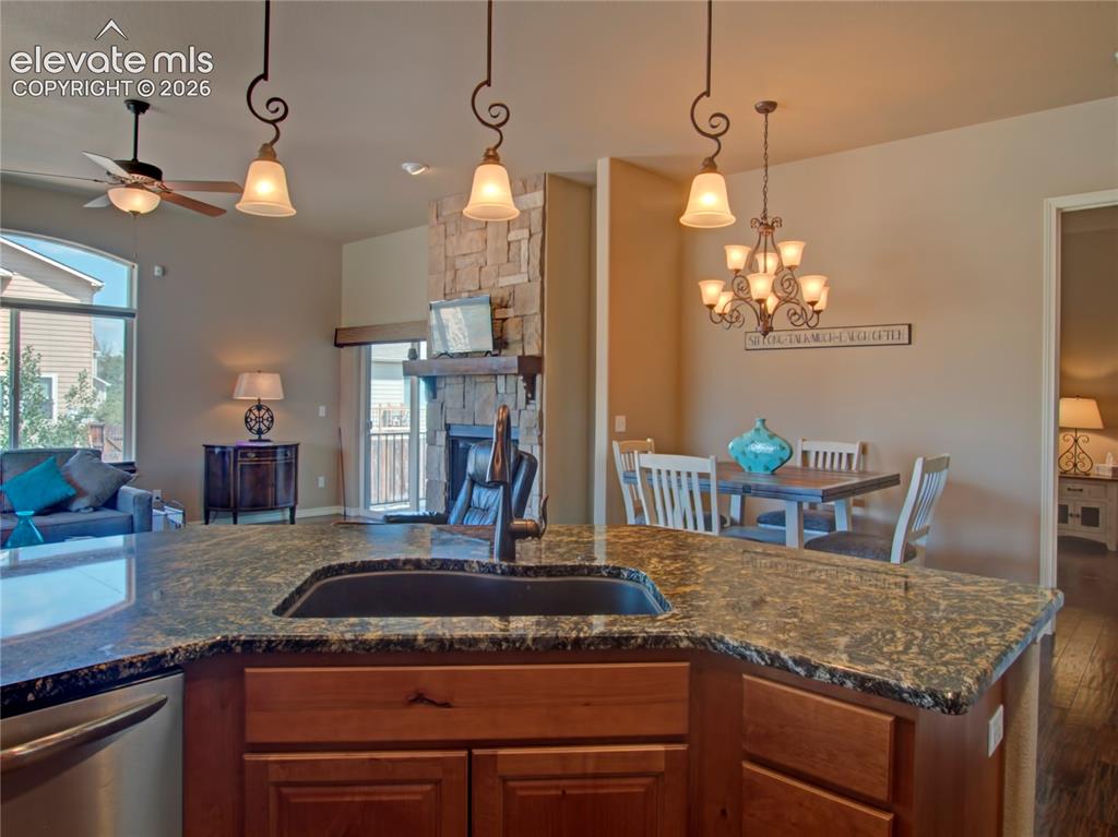 Image 11 of 33: Kitchen island featuring a dark granite countertop with an integrated sink 