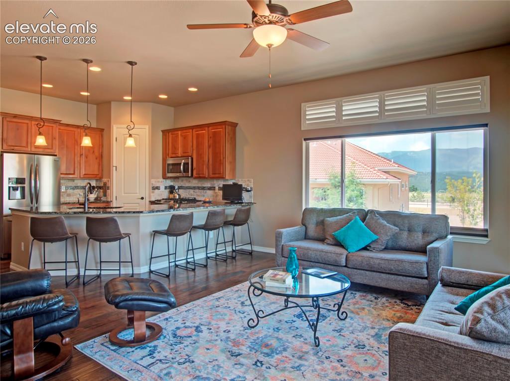 Image 14 of 33: Open-concept living space featuring wood-finish flooring and a ceiling fan 