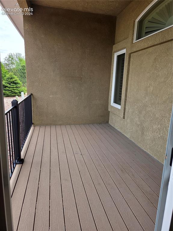 Image 17 of 33: Outdoor patio featuring composite decking, stucco exterior, and a black wro