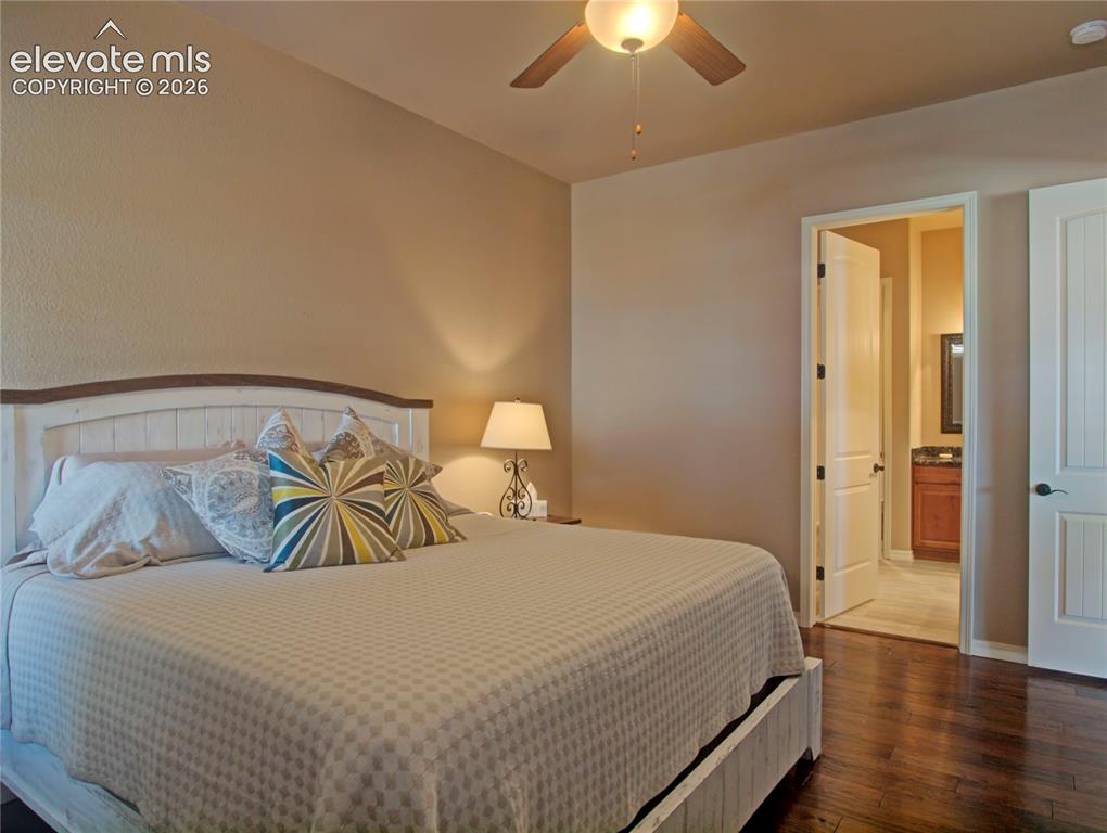 Image 20 of 33: Bedroom featuring dark wood-finish flooring, a ceiling fan with integrated 