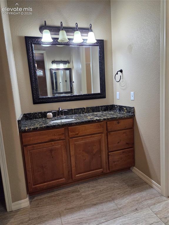 Image 22 of 33: @nd master Bathroom vanity-HERS, featuring a dark stone countertop, wood-fi