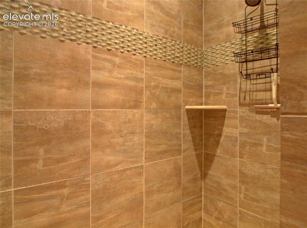 Image 25 of 33: adjoining bath with walk in large shower surround.