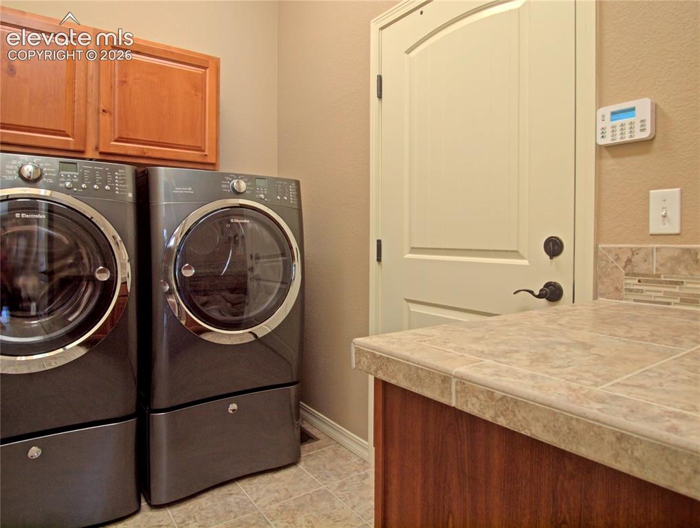 Image 26 of 33: Dedicated laundry area, storage closet  and garage door exit, featuring a t