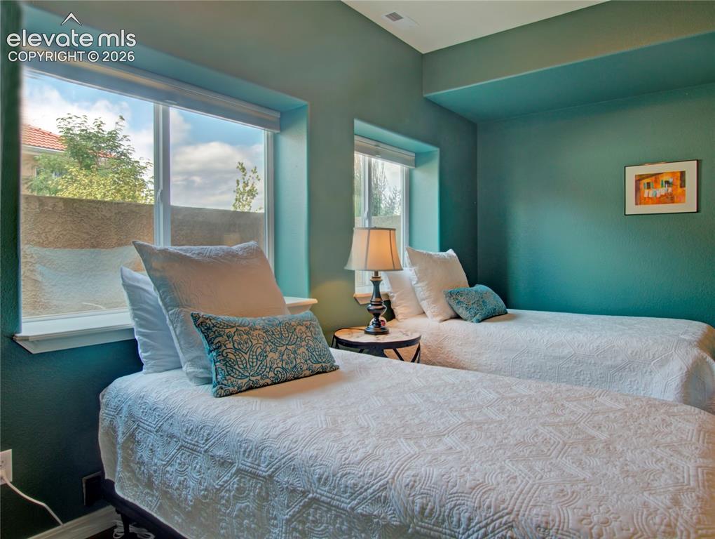 Image 27 of 33: third lower Bedroom featuring multiple windows, recessed lighting, and a co