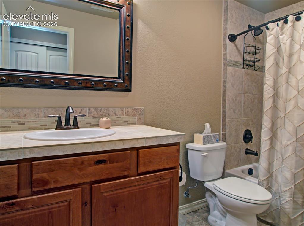 Image 28 of 33: Lower level Bathroom vanity with one sink, full bath tub ,tile countertop, 