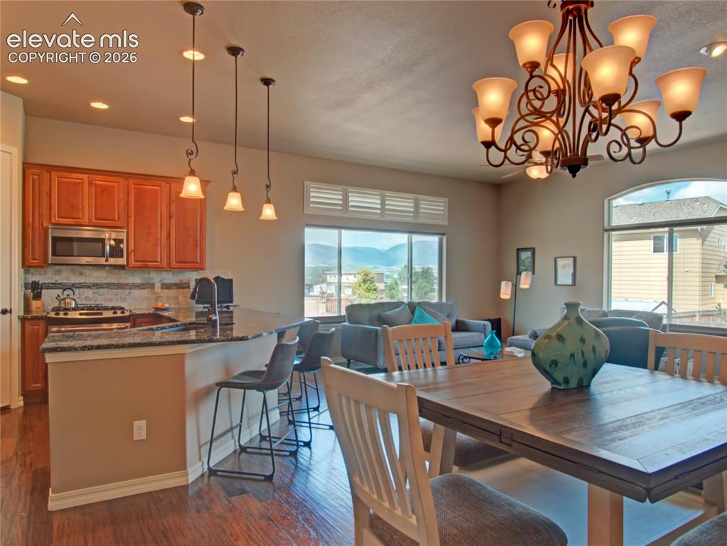 Image 9 of 33: Open-concept living space featuring wood-finish flooring, a kitchen with ri