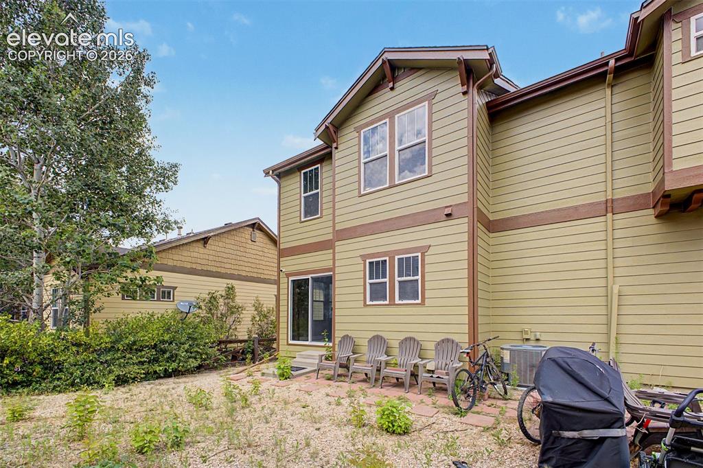 Image 34 of 35: Two-story exterior with siding, multiple windows, and a sliding glass door