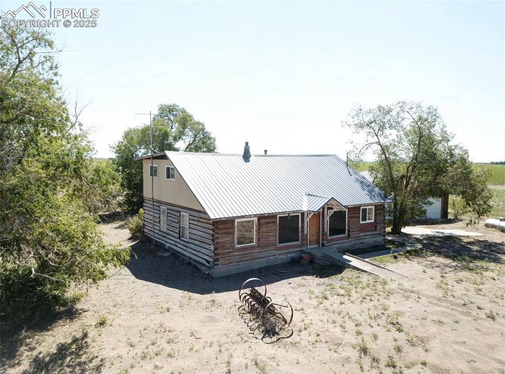 Image 5 of 7: View of front facade with log exterior and metal roof