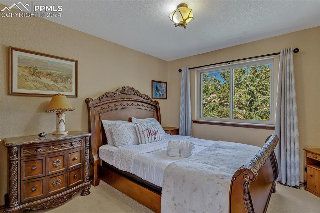 Image 19 of 40: Upper Bedroom, 2nd Bedroom, Wooden Bed, Carpeted Floor,