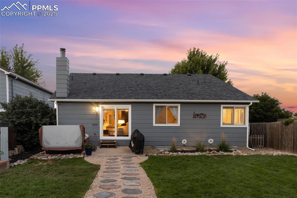 Image 14 of 39: View of front of property featuring a chimney, a patio, roof with shingles,