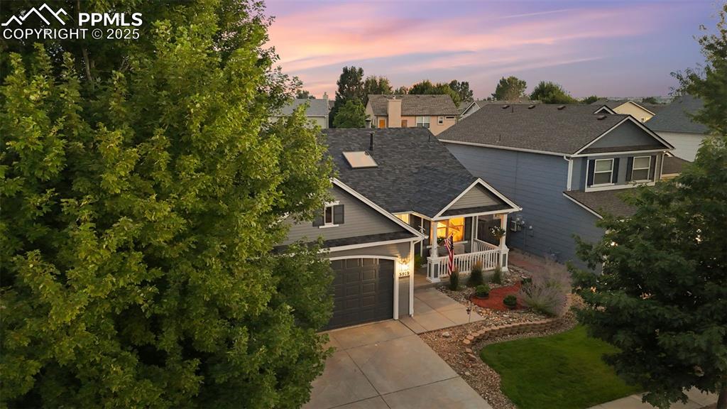 Image 2 of 39: View of front of property featuring a porch, concrete driveway, roof with s