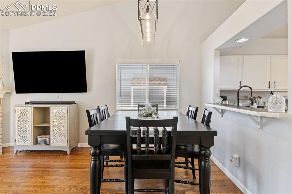 Image 22 of 39: Dining area with wood finished floors, recessed lighting, and vaulted ceili