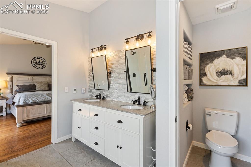 Image 30 of 39: Full bath featuring double vanity, light tile patterned floors, tasteful ba