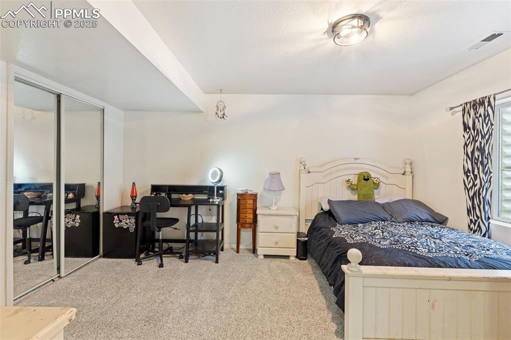 Image 31 of 39: Carpeted bedroom featuring a desk and a closet