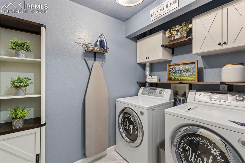 Image 37 of 39: Laundry room featuring a textured wall, independent washer and dryer, and c