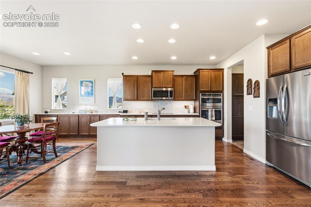 Image 12 of 49: Open floor plan of kitchen and eat-in area featuring mountain views, hardwo