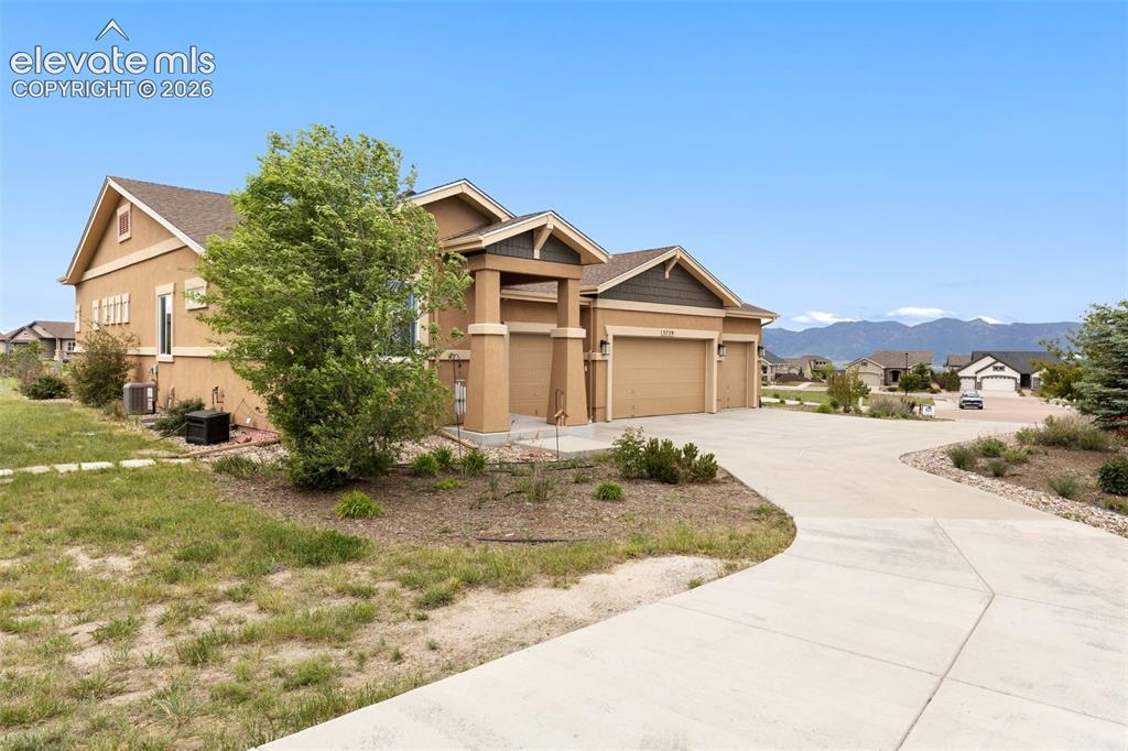 Image 36 of 49: Front of house with 4 car garage and mountain views