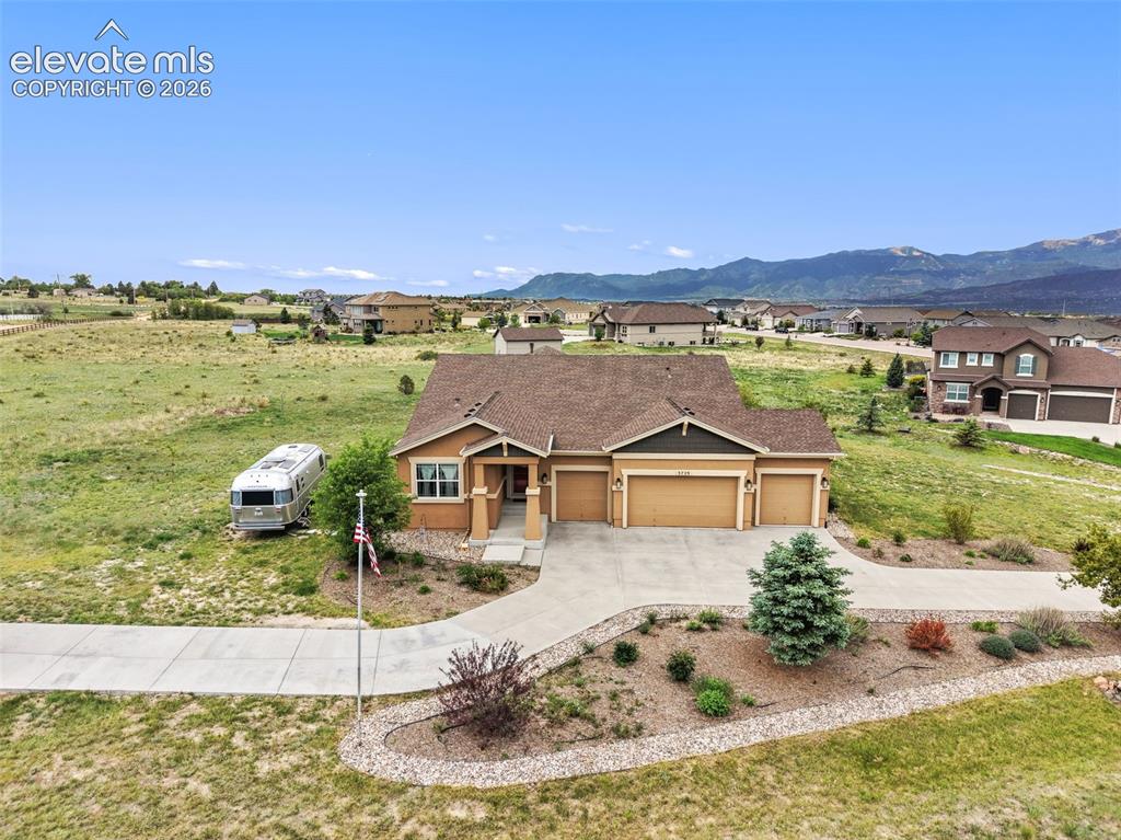 Image 45 of 49: Aerial view of property with mountains as backdrop