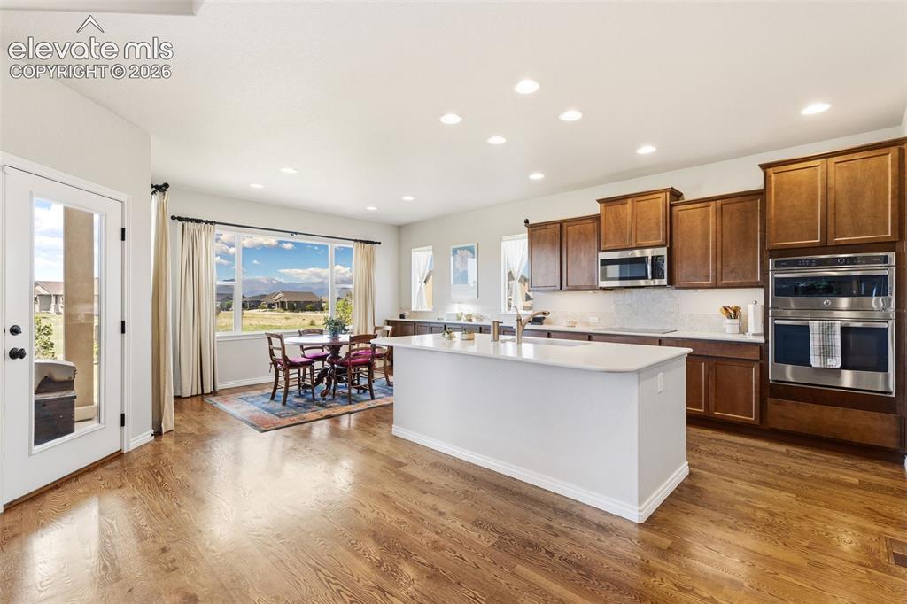 Image 6 of 49: Open floor plan of kitchen and eat-in area featuring mountain views, hardwo