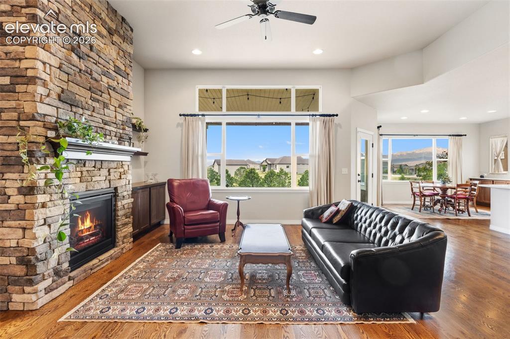 Image 8 of 49: Living room with view across back of property and stunning brick fireplace
