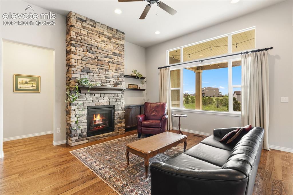 Image 9 of 49: Living room with view across back of property and stunning brick fireplace