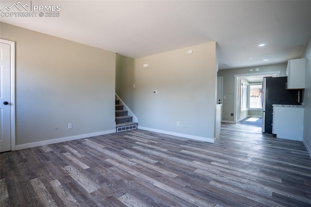 Image 6 of 24: Entry way showing stairs and peeking into kitchen
