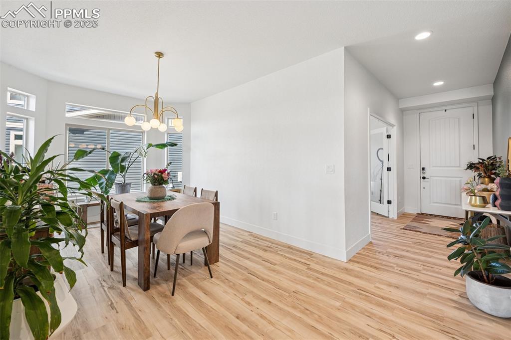 Image 11 of 43: Dining space with light wood-style floors, recessed lighting, and a chandel