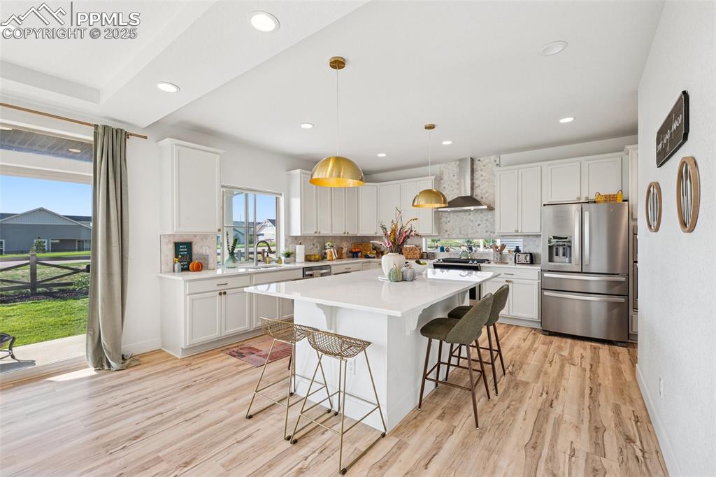 Image 13 of 43: Kitchen with decorative backsplash, a kitchen breakfast bar, stainless stee