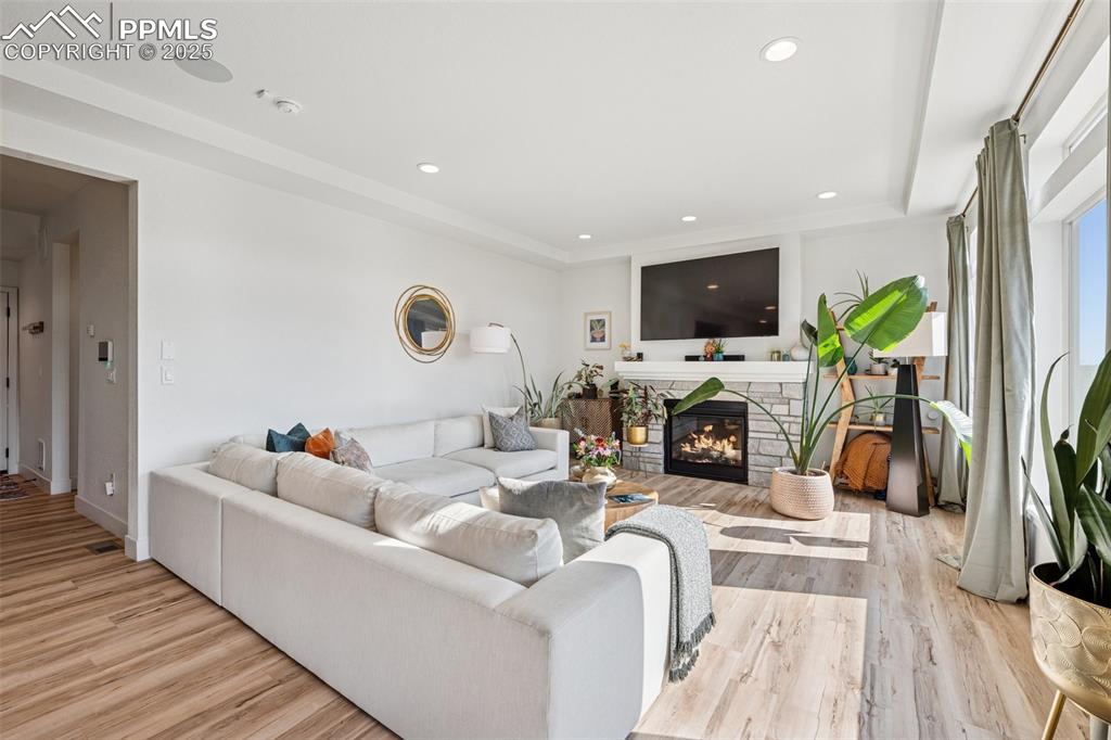 Image 16 of 43: Living room with a fireplace, light wood-style floors, and recessed lightin