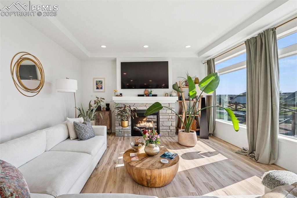 Image 18 of 43: Living area with wood finished floors, recessed lighting, a fireplace, and 