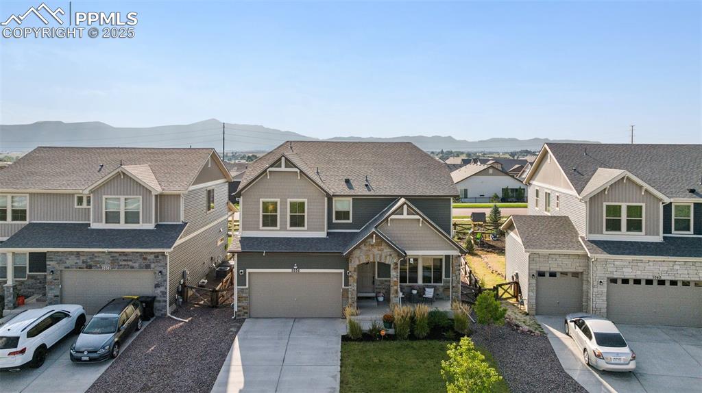 Image 2 of 43: Craftsman-style home with a residential view, stone siding, driveway, and a