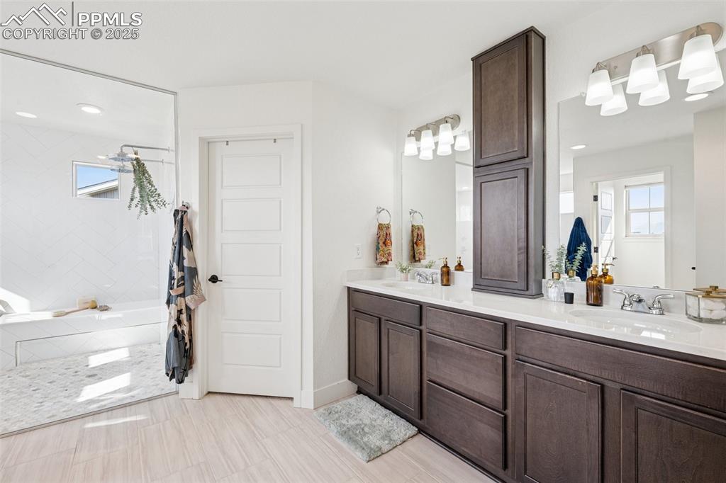 Image 21 of 43: Bathroom with double vanity, recessed lighting, and light tile patterned fl