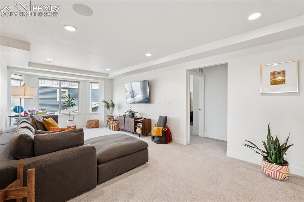 Image 25 of 43: Carpeted living room featuring recessed lighting and a raised ceiling