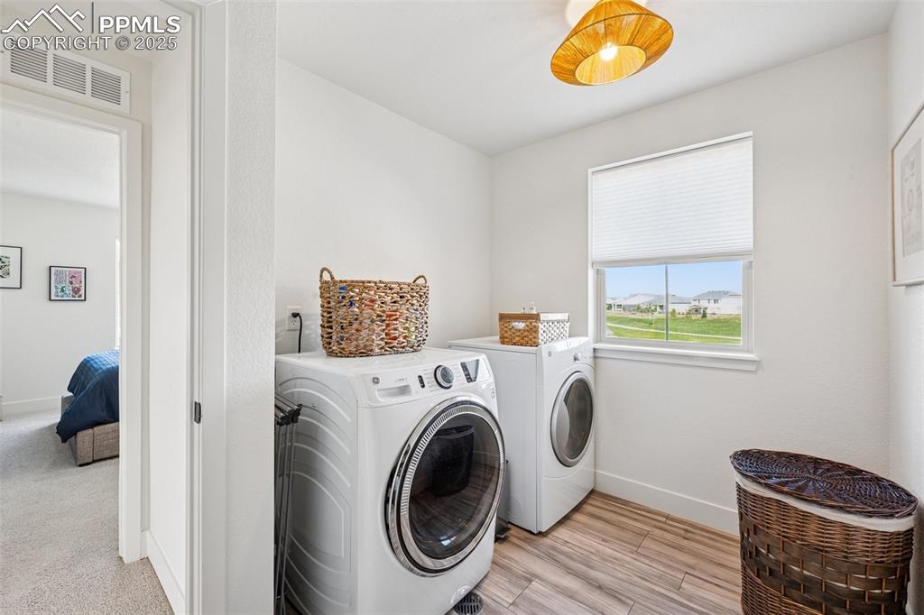 Image 29 of 43: Washroom featuring separate washer and dryer and light wood-type flooring