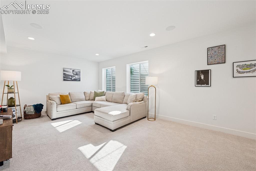 Image 35 of 43: Living room featuring light colored carpet and recessed lighting