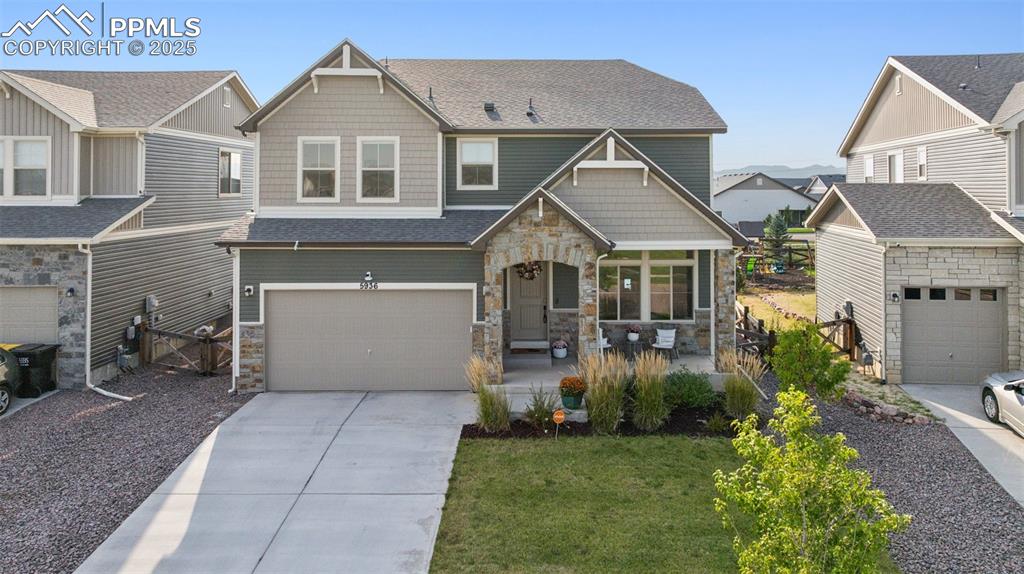 Image 5 of 43: Craftsman-style home featuring stone siding, roof with shingles, a resident