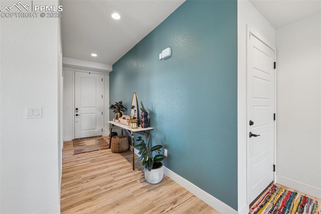 Image 6 of 43: Corridor with a textured wall, light wood-style flooring, and recessed ligh