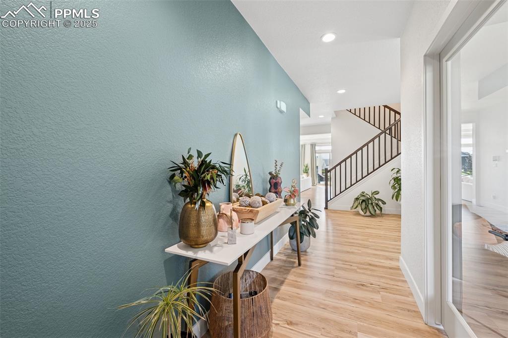 Image 7 of 43: Hall with a textured wall, light wood-type flooring, recessed lighting, and