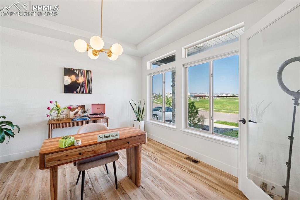Image 8 of 43: Office area featuring light wood-style floors and a chandelier