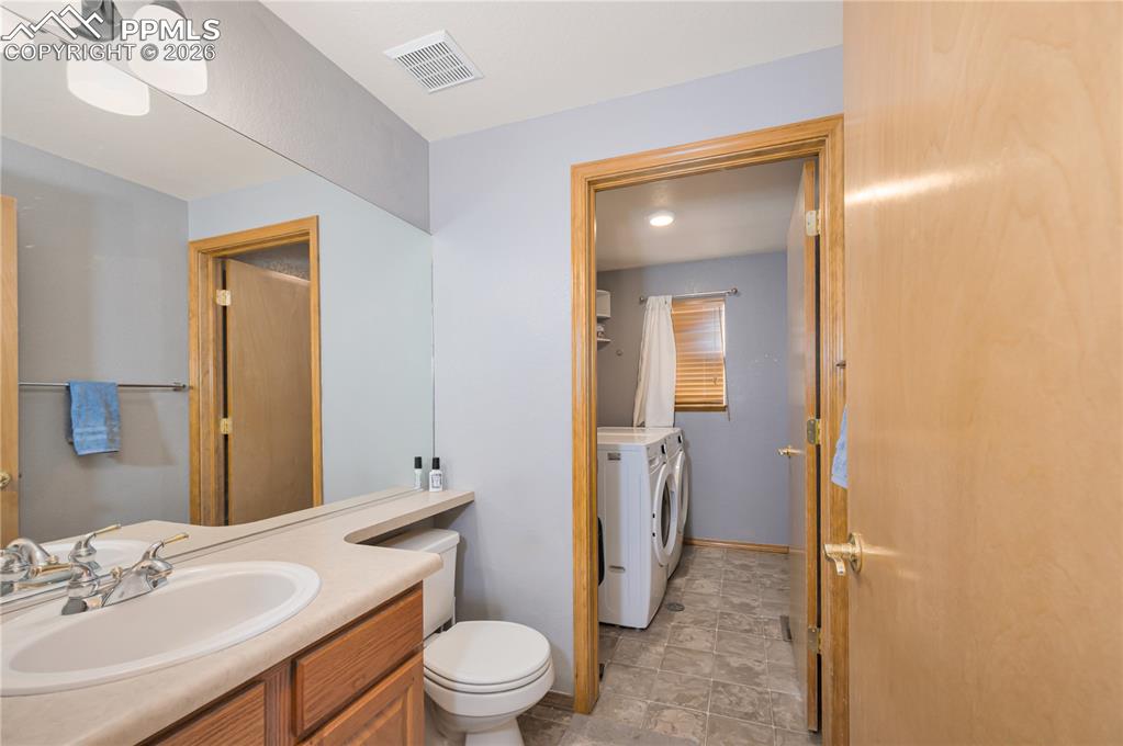 Image 11 of 30: Main level bathroom and laundry