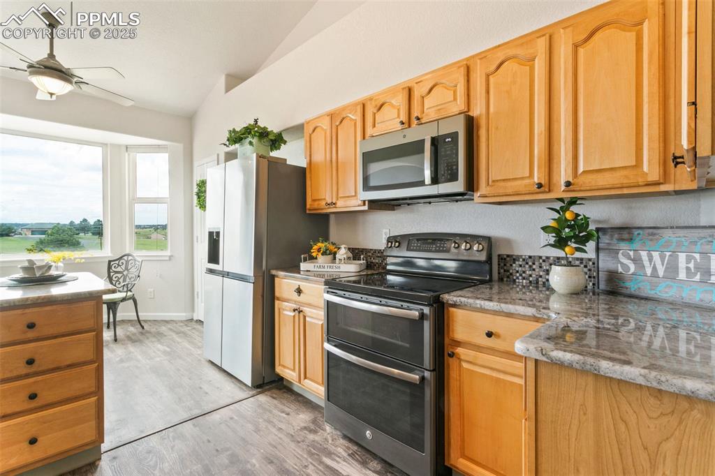 Image 12 of 44: Kitchen featuring appliances with stainless steel finishes, lofted ceiling,