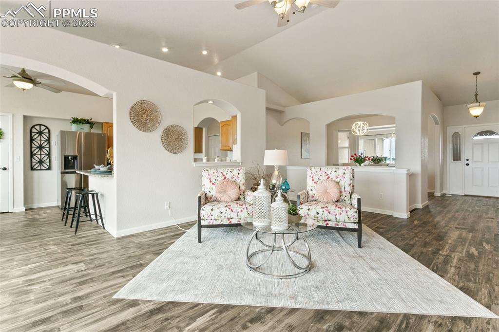 Image 14 of 44: Living area featuring a ceiling fan, lofted ceiling, wood finished floors,