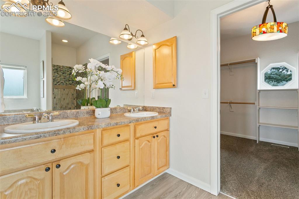 Image 21 of 44: Full bathroom featuring double vanity, wood finished floors, a shower, and